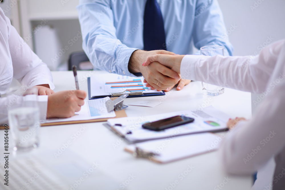 Business people handshake, sitting at the table Business people handshake, sitting at the table