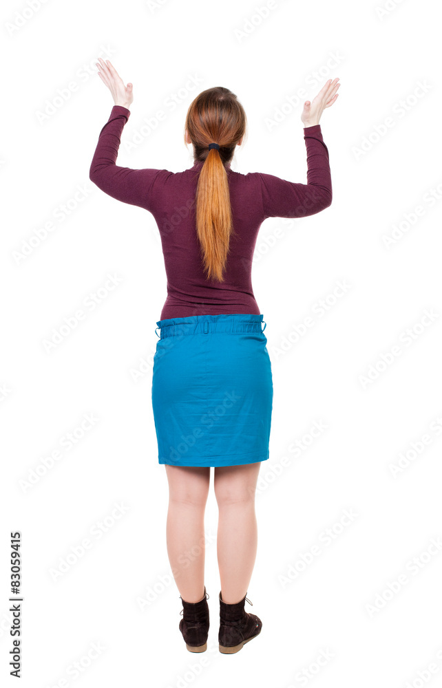 Back view of Beautiful woman in jeans looking at wall and Holds Back view of Beautiful woman in jeans looking at wall and Holds