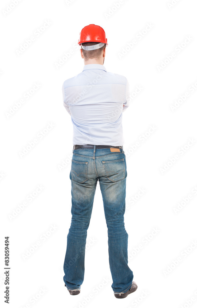Backview of an engineer in construction helmet stands Backview of an engineer in construction helmet stands