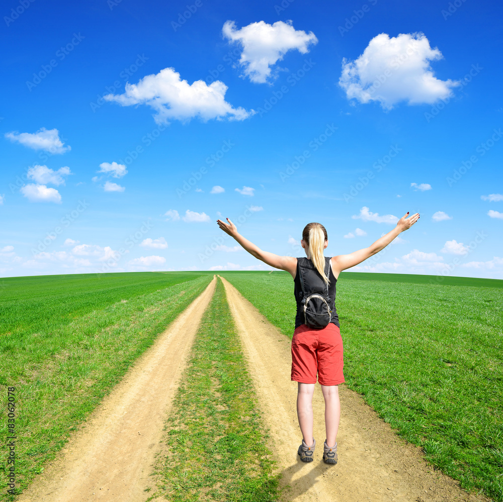 Girl standing on a meadow trail Girl standing on a meadow trail