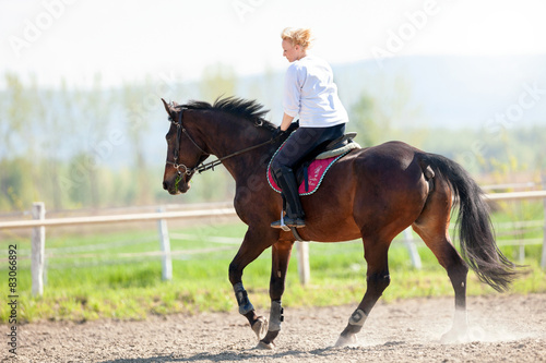 Beautiful blonde woman riding a horse