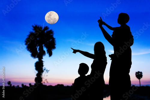 Parents and children look at the full moon