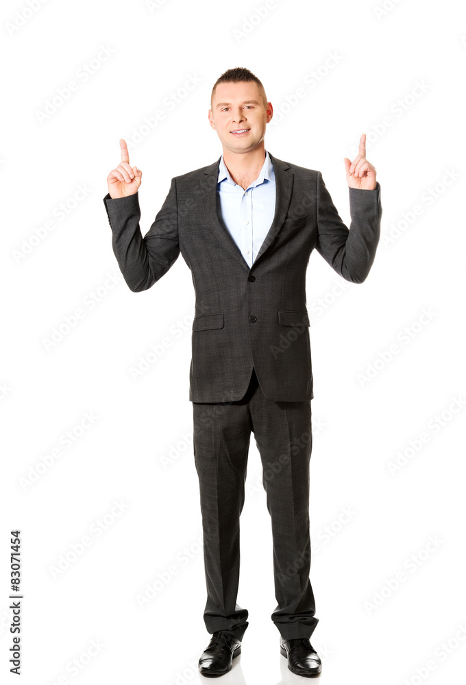 Young businessman pointing upwards Young businessman pointing upwards