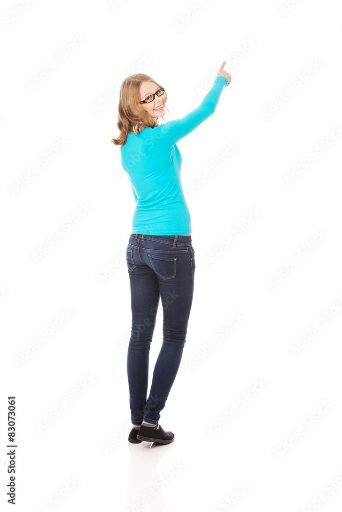 Obraz premium Young woman pointing up 
