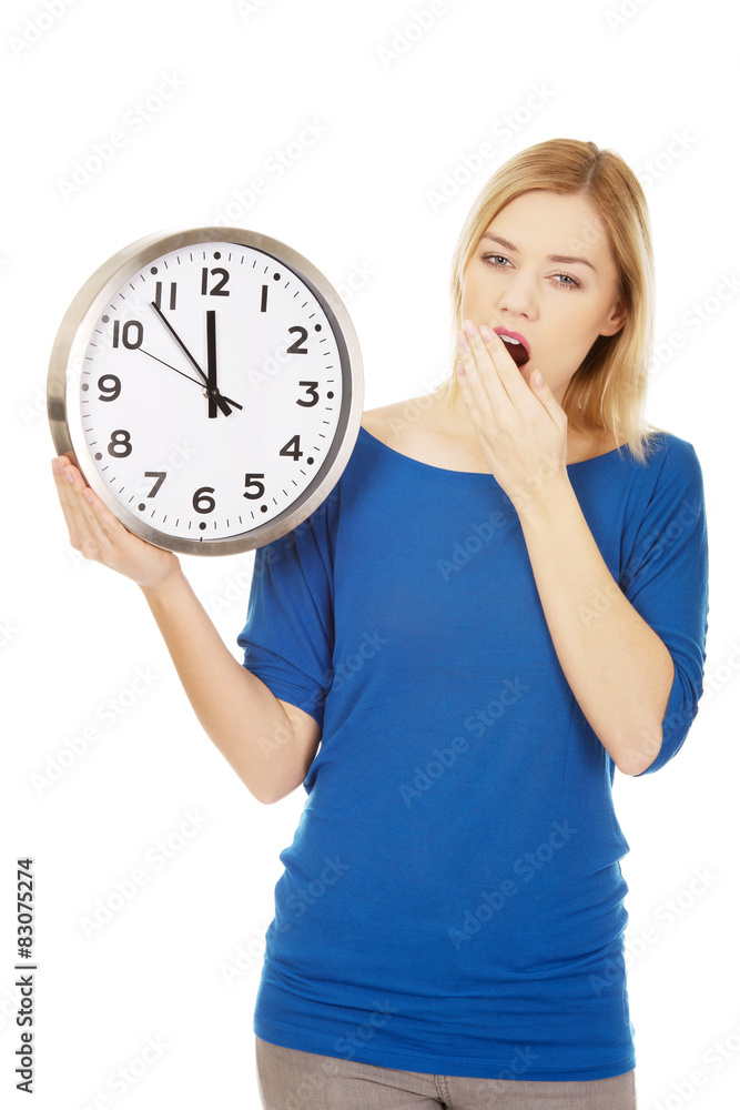 Tired woman holding a clock.