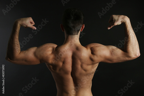 Muscle young man on black background