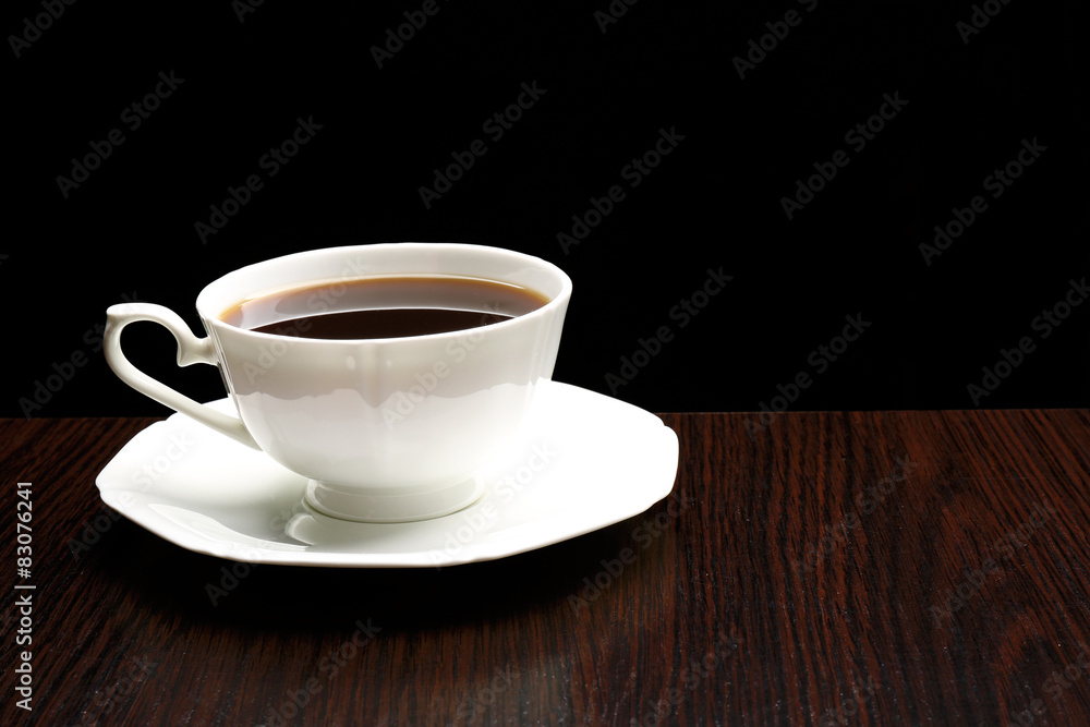 Cup of coffee on wooden table, on dark background Cup of coffee on wooden table, on dark background