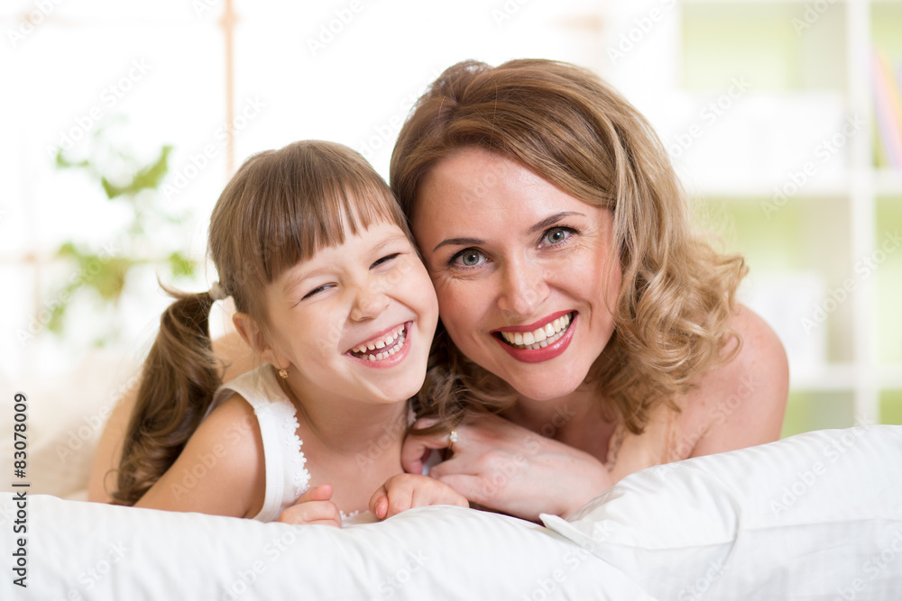 Portrait of a joyful mother and her daughter lying on bed Portrait of a joyful mother and her daughter lying on bed
