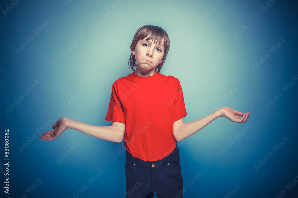 European-looking boy of twelve years in the hat on a gray bac European-looking boy of twelve years in the hat on a gray bac