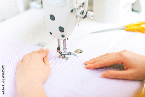 Woman's hands working on sewing machine.