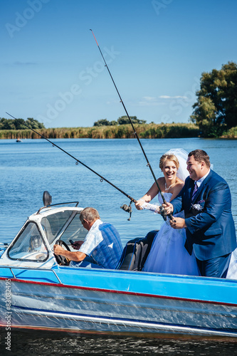 Newly married couple riding in boat on river