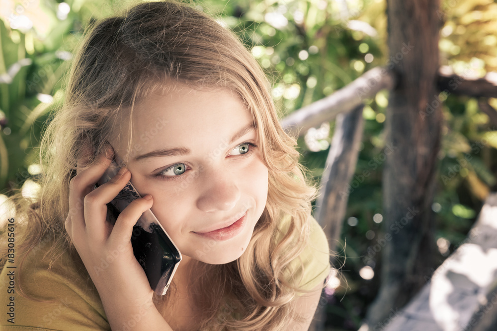 Teenage girl in a park talking on a cell phone Teenage girl in a park talking on a cell phone