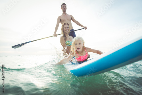 family making paddle surf in the ocean