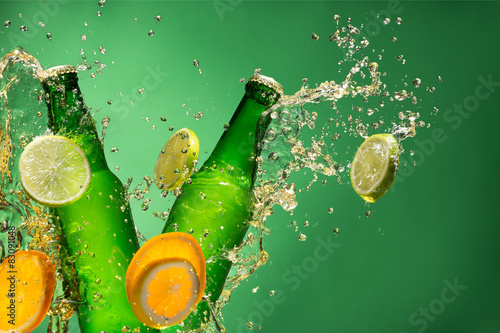 Bottles of fruit beer with splash, on gree photo