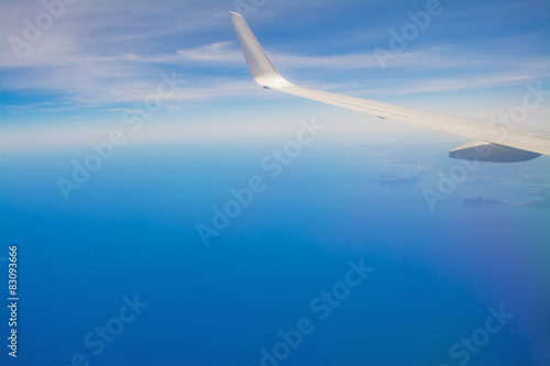 white airplane wing in the blue sky