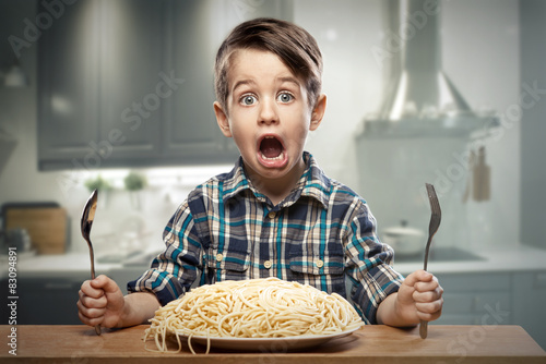 Startled yound boy with noodles photo