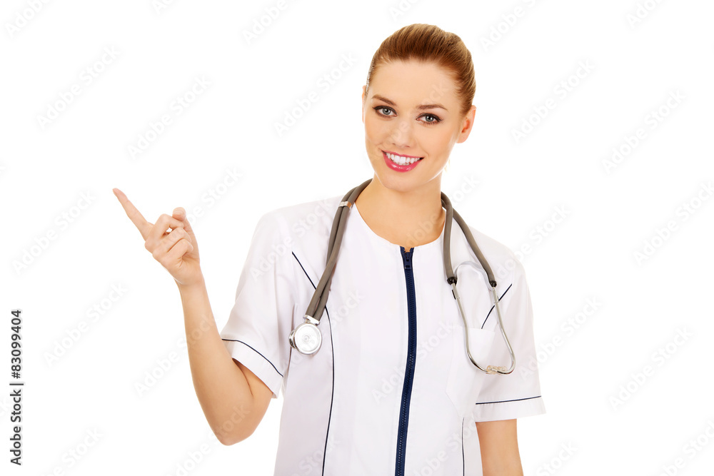 Medical doctor woman pointing up. Medical doctor woman pointing up.
