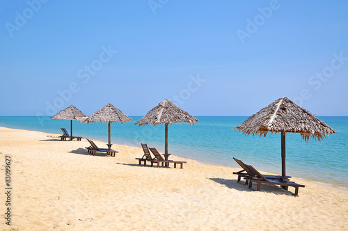 Beach chairs and umbrellas on a beautiful panoramic beach view a © underverse