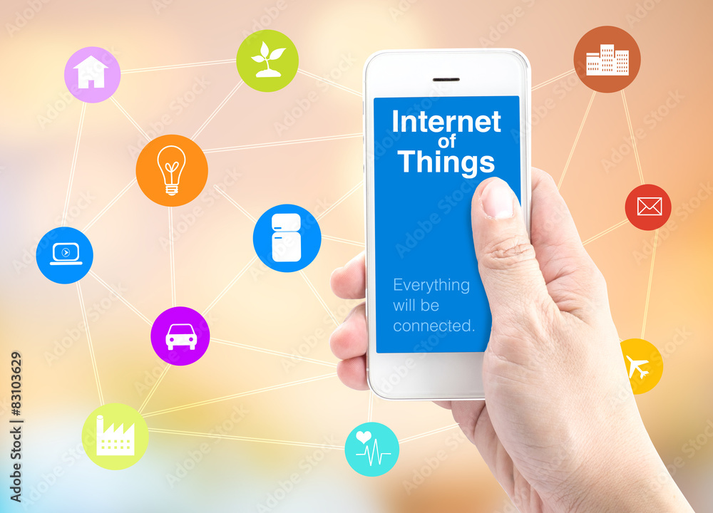 Hand holding smartphone with Internet of things (IoT) word and o Hand holding smartphone with Internet of things (IoT) word and o