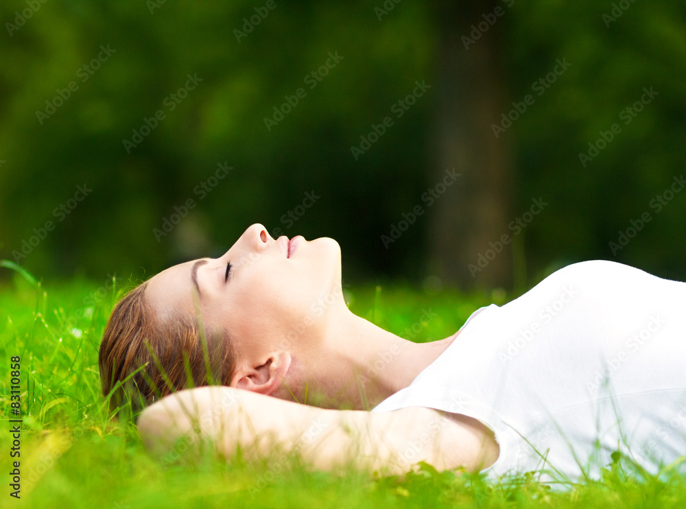 Young woman lying on grass and relaxing in park. Young woman lying on grass and relaxing in park.