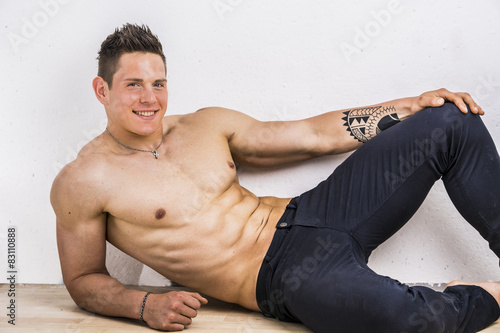 Handsome young bodybuilder laying down on the floor