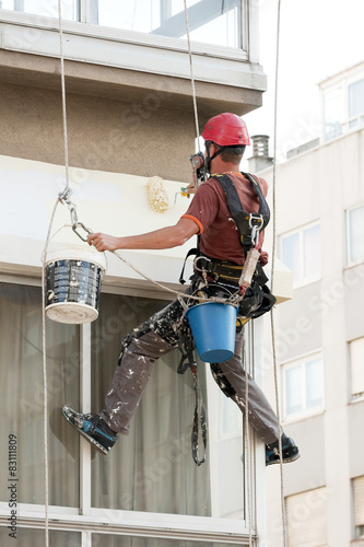 vertical worker of high risk repair a building facade