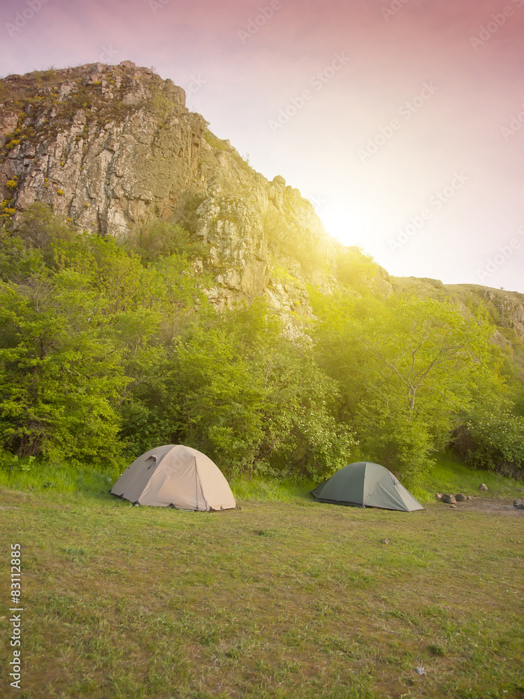 Two large tents were pitched in the forest near the mountains in
