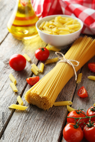 Spaghetti with pasta and tomatoes on wooden background