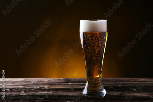 Glass of beer on brown wooden background