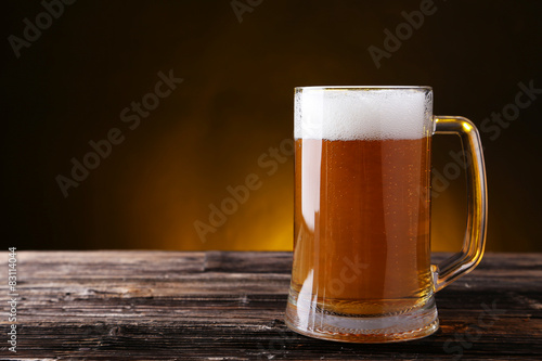Mug of beer on brown wooden background
