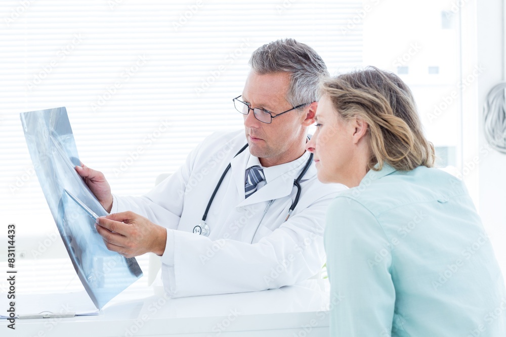 Doctor having conversation with his patient and holding xray Doctor having conversation with his patient and holding xray