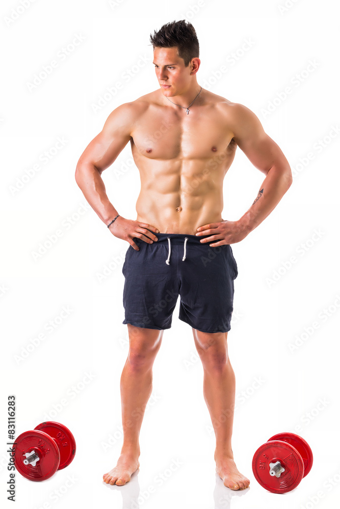 Handsome muscular shirtless young man holding dumbbells