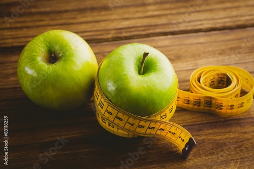 Green apples with measuring tape