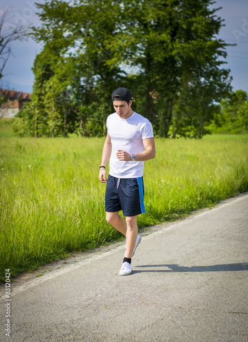 Young man running and jogging on road in country © theartofphoto