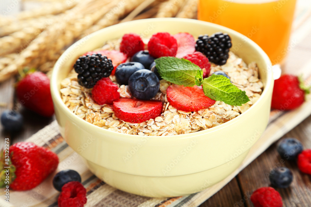 Oatmeal with berries on brown wooden background