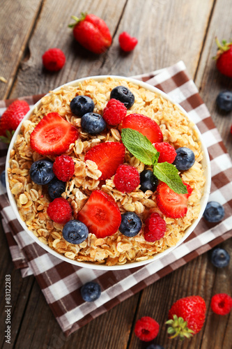 Oatmeal with berries on brown wooden background