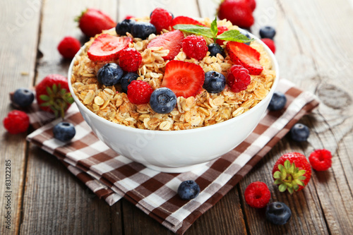 Oatmeal with berries on brown wooden background