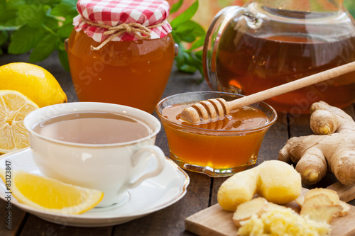 Cup of ginger tea with honey and lemon on wooden table 