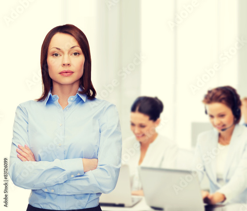 smiling businesswoman with crossed arms at office