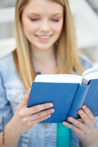 close up of young woman reading book at school