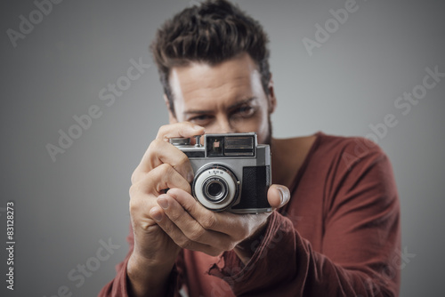 Young man taking pictures with a vintage camera