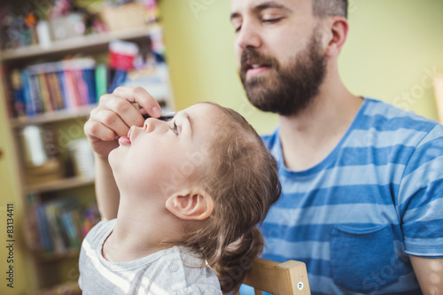 Young father styling hair of his daughter