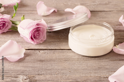 Slika na platnu cosmetic cream with pink roses on old wooden table