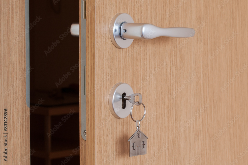 Obraz premium door handle with inserted key with house icon keyring