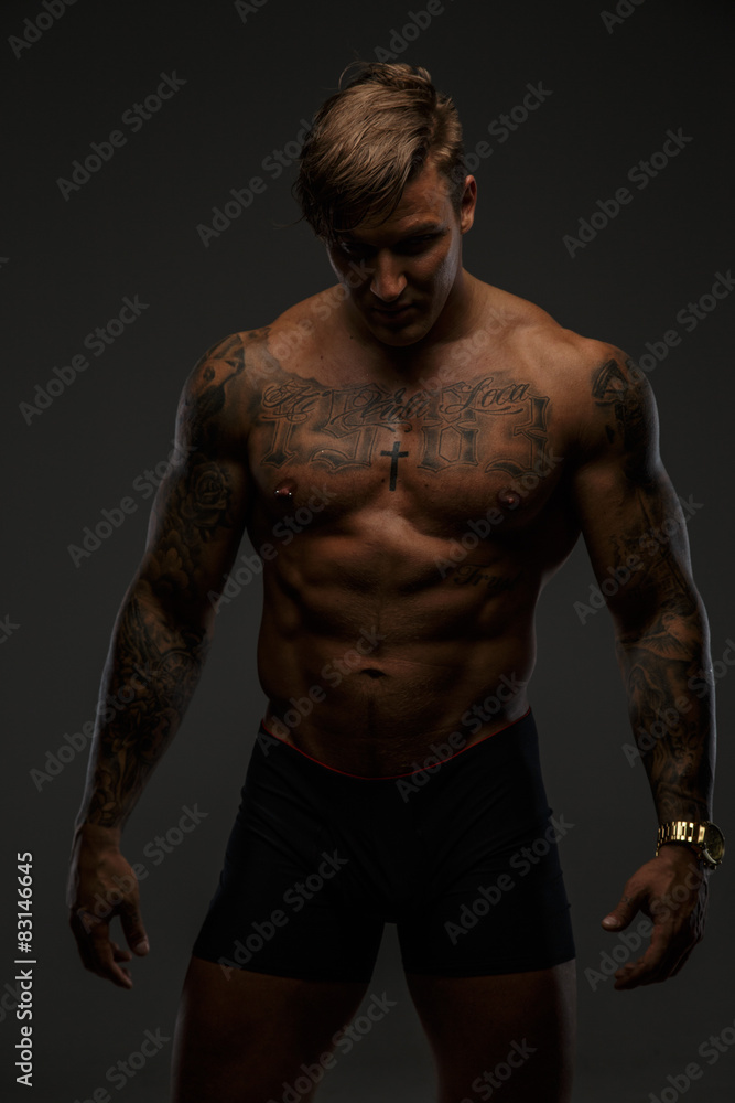 Fototapeta premium Muscular guy in deep shadows