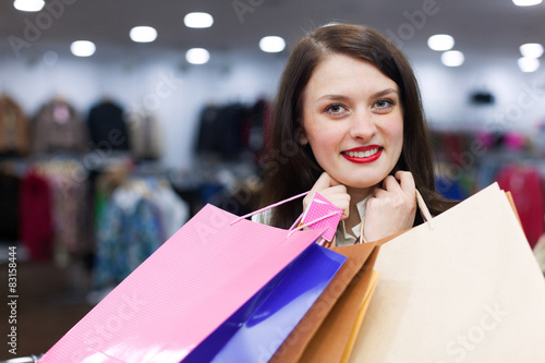 Young woman with a lot of shopping bags at fashionable store