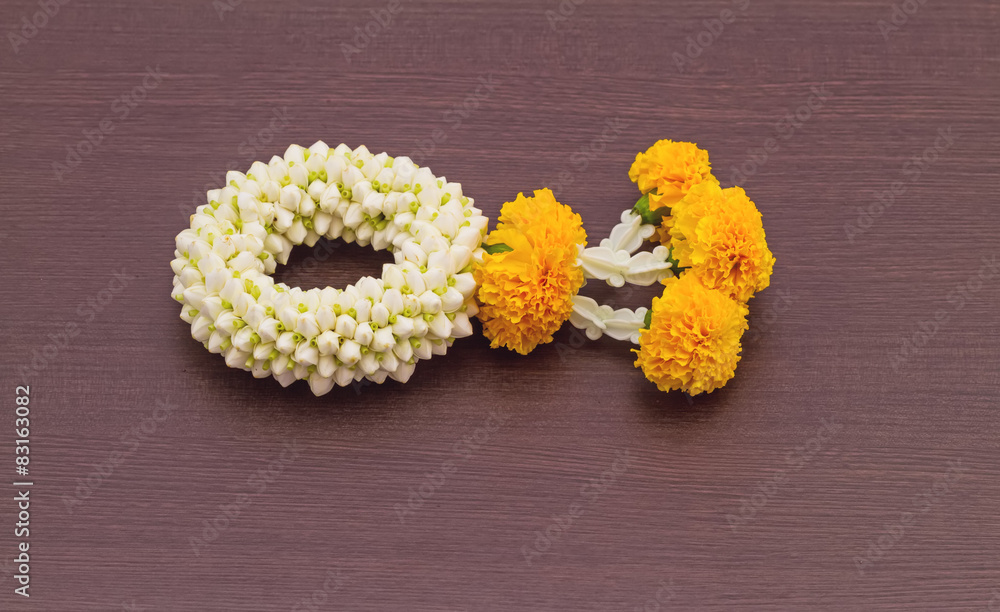 Close up jasmine garland of flowers on black wooden background Close up jasmine garland of flowers on black wooden background