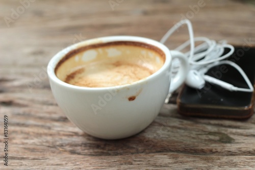 latte coffee in cup on wood background and smart phones