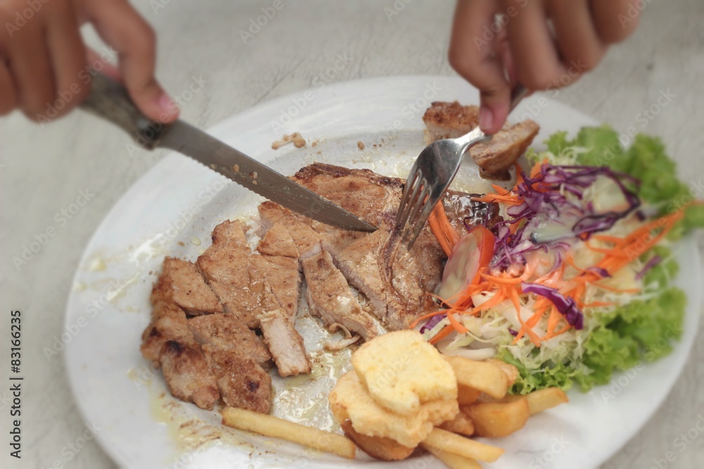 steaks and vegetable salad with french fries.