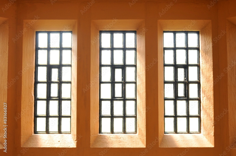 Fototapeta premium Abstract view of symmetrical windows on purple wall